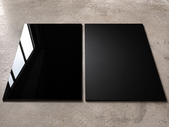 Comparaison entre une plaque de Plexiglass noir brillant et une plaque satinée mat en lumière rasante